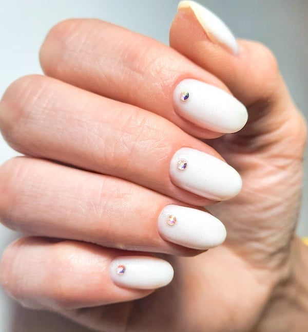 Short white nails with rhinestones.