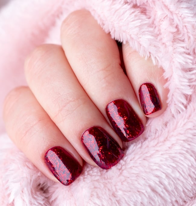 Short crimson glitter nails.