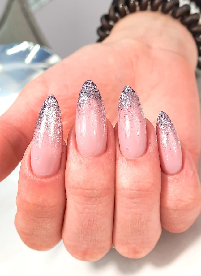 Silver pink sparkling almond stiletto nails.