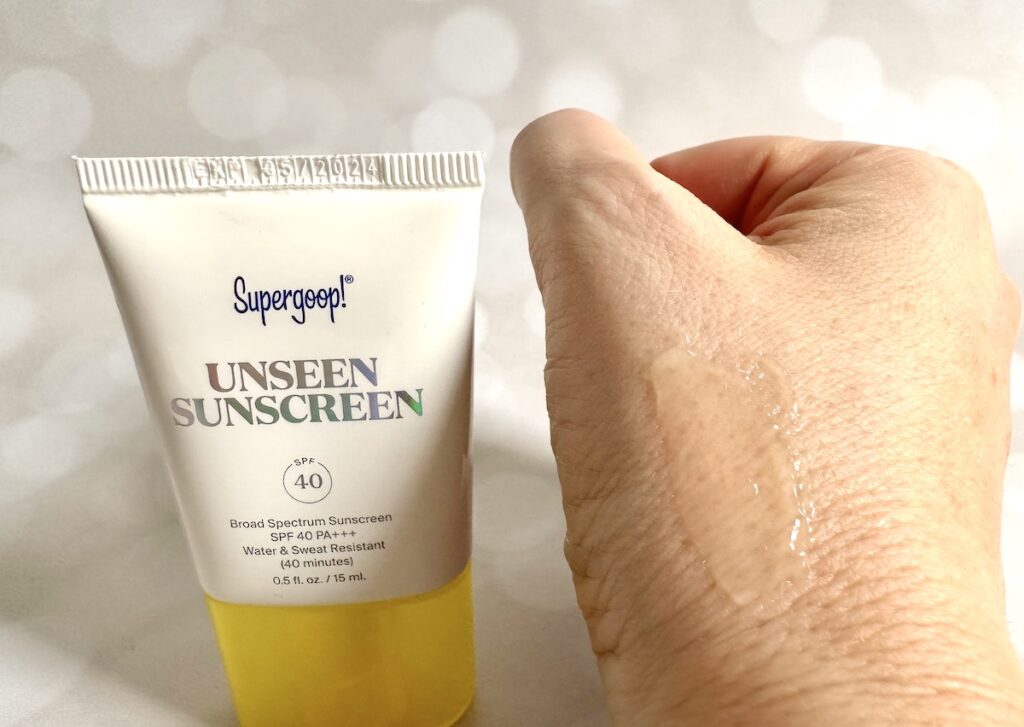 Supergoop! Unseen Sunscreen SPF 40, flatlay of tube next to sample on hand.