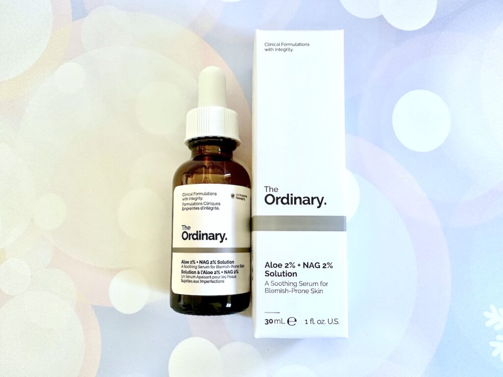 The Ordinary Aloe 2% + NAG 2% Solution, flatlay of bottle next to box.