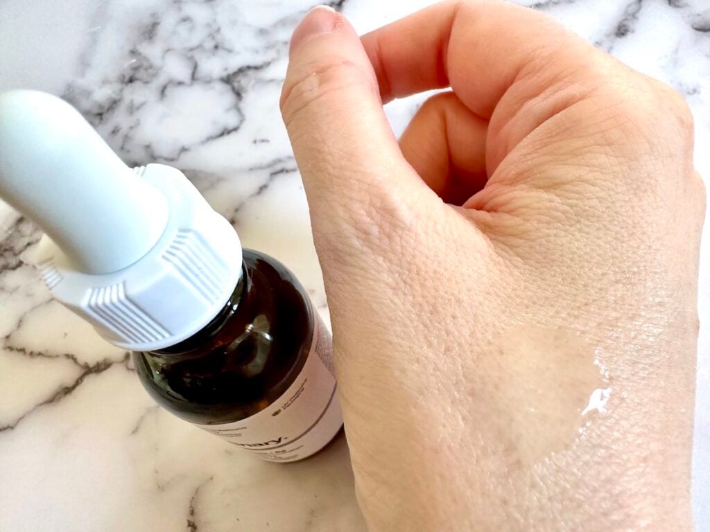 The Ordinary Amino Acids + B5 bottle next to sample on hand.