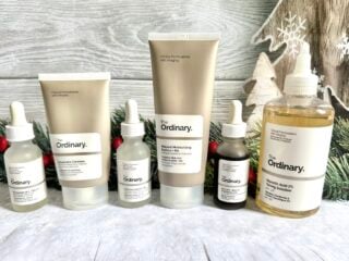 The Ordinary Black Friday Sale: The Ordinary Squalane Cleanser, The Ordinary Hyaluronic Acid, AHA 30% + BHA 1% Peeling Solution, The Ordinary Niacinamide Serum, The Ordinary Natural Moisturizing Factors + HA, and The Ordinary Glycolic Acid 7% Toning Solution in front of Christmas holly.