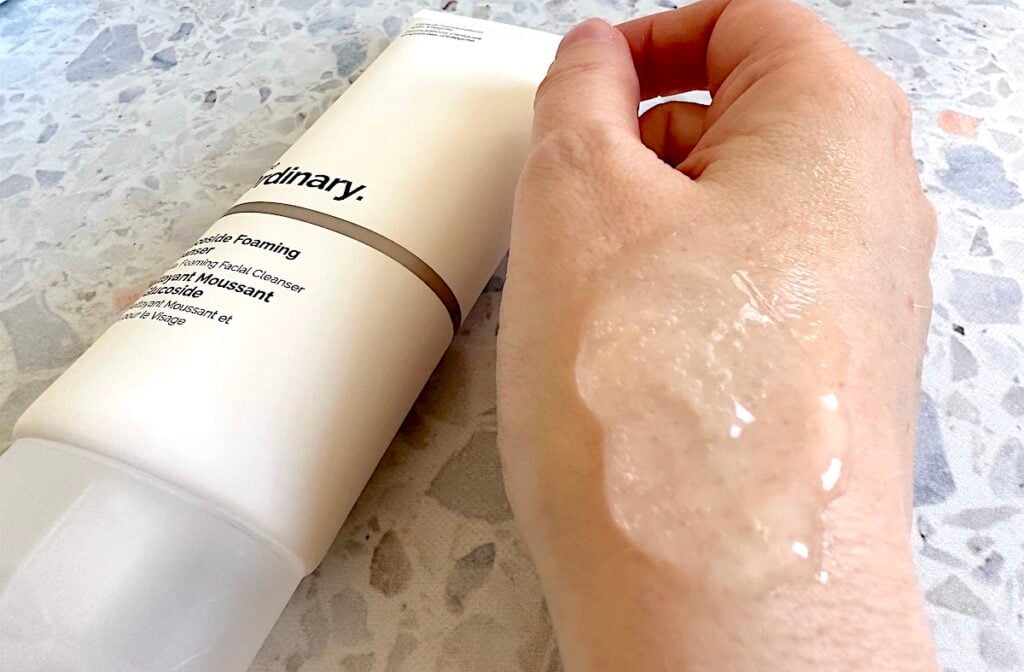 The Ordinary Glucoside Foaming Cleanser bottle and clear gel cleanser sampled on hand.