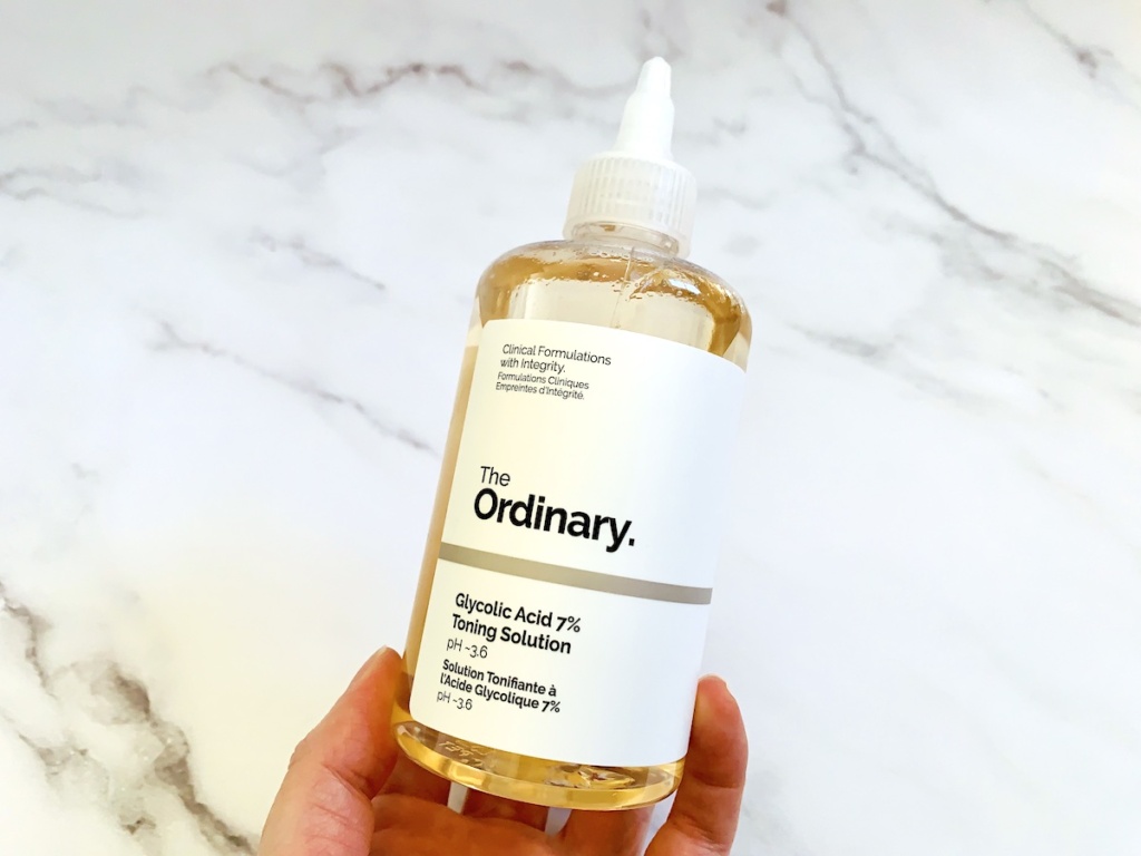 The Ordinary Glycolic Acid 7% Toning Solution handheld on white marble background