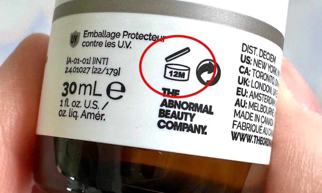 The Ordinary Expiration Dates: PAO Symbol of 12M circled in red on side of The Ordinary bottle, handheld.