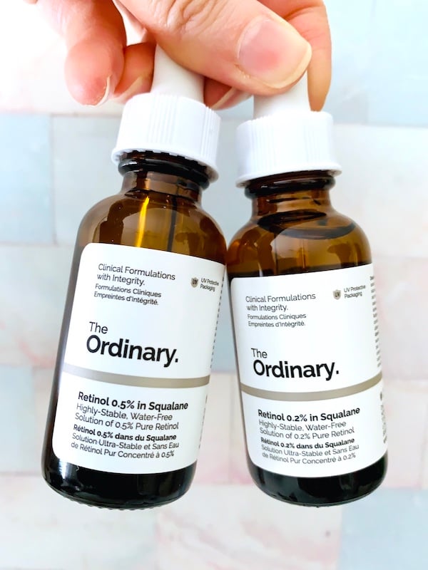 The Ordinary Retinol 0.5% in Squalane serum and The Ordinary Retinol 0.2% in Squalane Serum held by hand