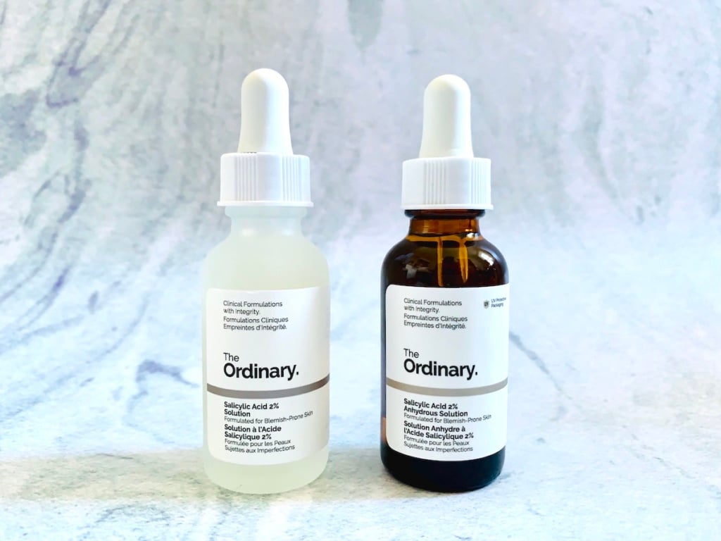 The Ordinary Salicylic Acid 2% Solution (Reformulated) and The Ordinary Salicylic Acid 2% Anhydrous Solution on blue background