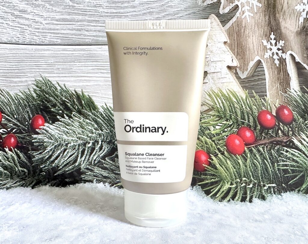 The Ordinary Squalane Cleanser, in front of Christmas holly.