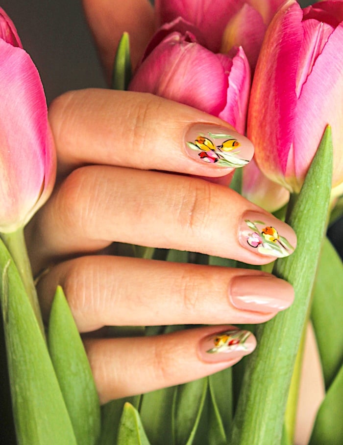 Tulip nail design on hand holding punk tulips.