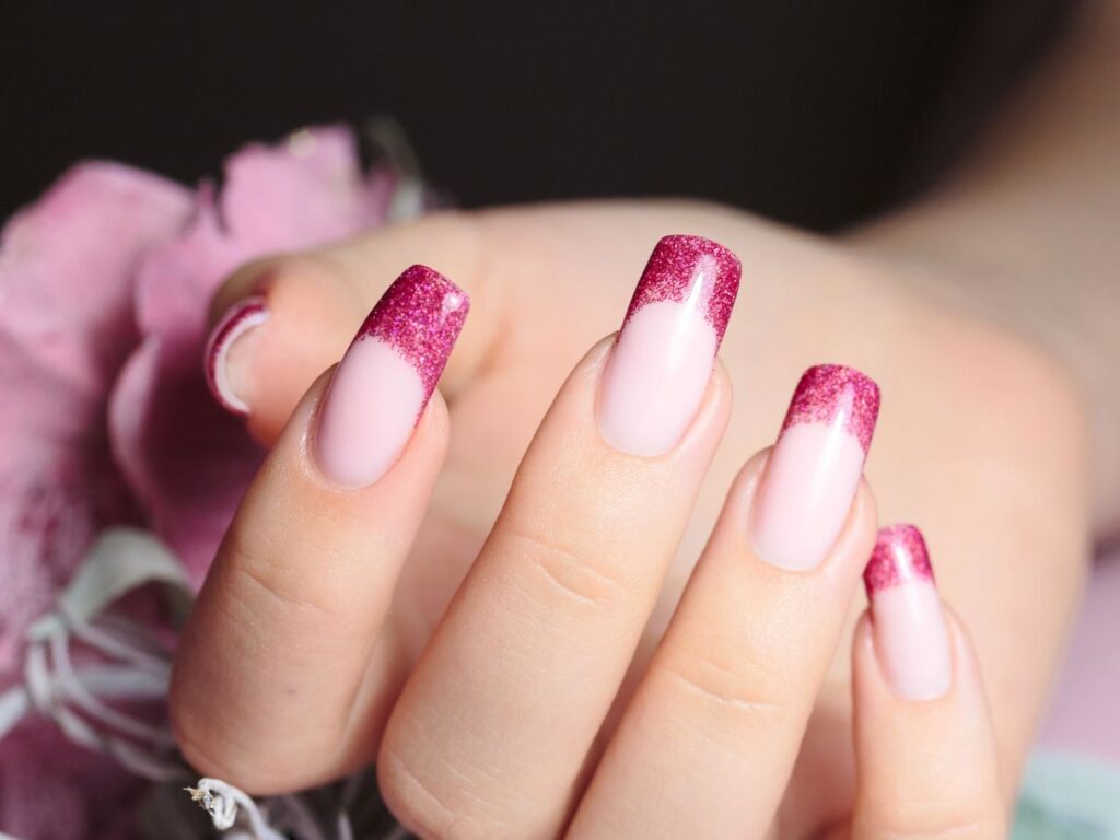 Bright pink glitter French tip nails for Valentines day.