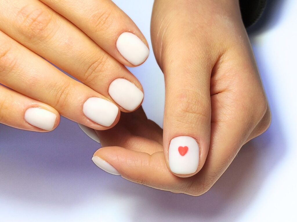 White matte nails with red heart.