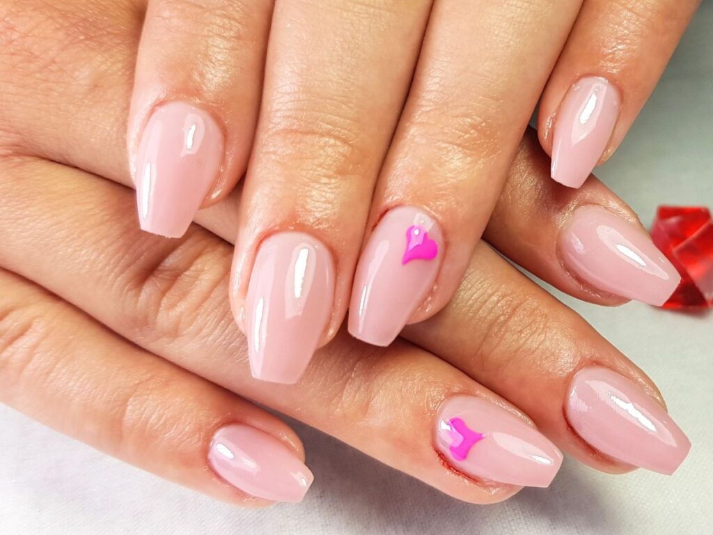 Pink coffin nails with a single fushia heart on each ring finger.