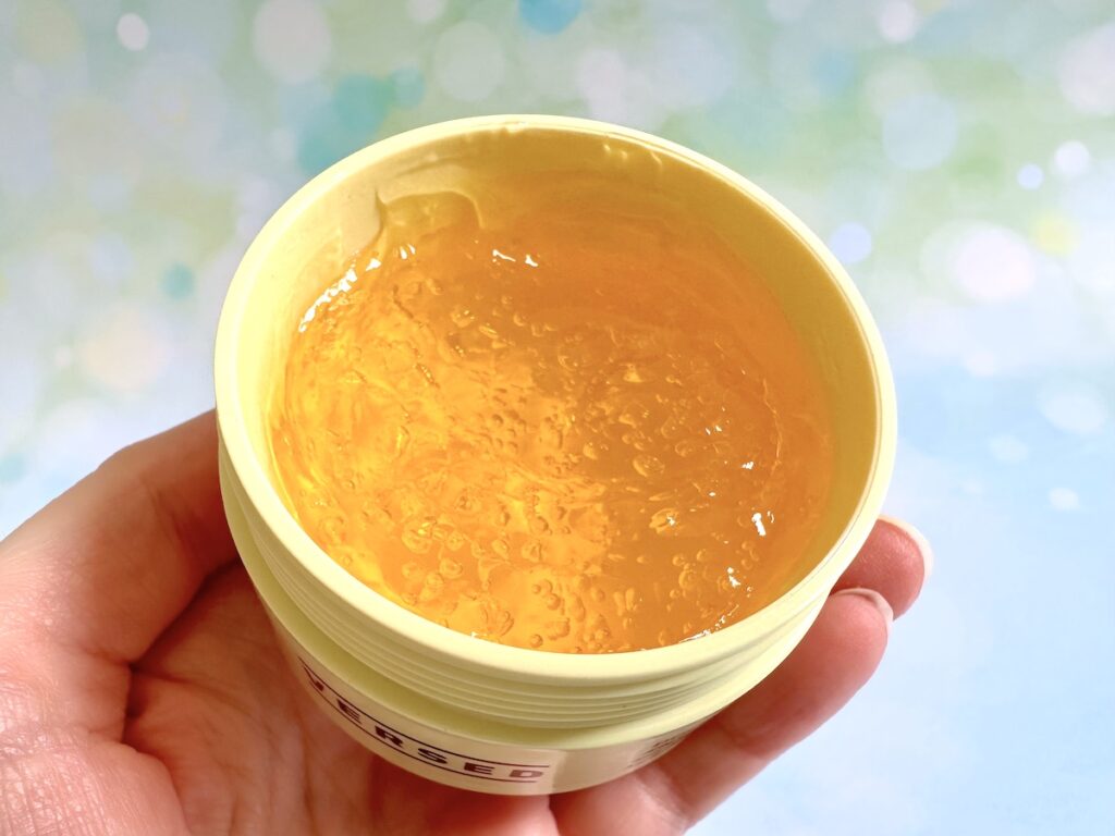 Versed Doctor's Visit Instant Resurfacing Mask, open jar with gold-shaded jelly mask, handheld.