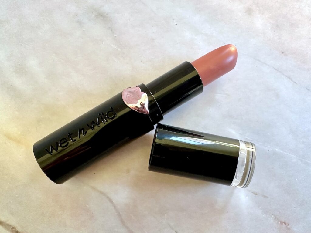 Wet N Wild Mega Last Matte Lip Color in the shade Bare It All, open with cap, flatlay.