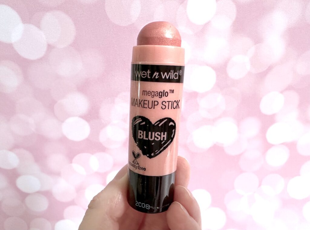 Wet N Wild Megaglo Makeup Stick Blush in Peach Bums, cap removed, handheld.