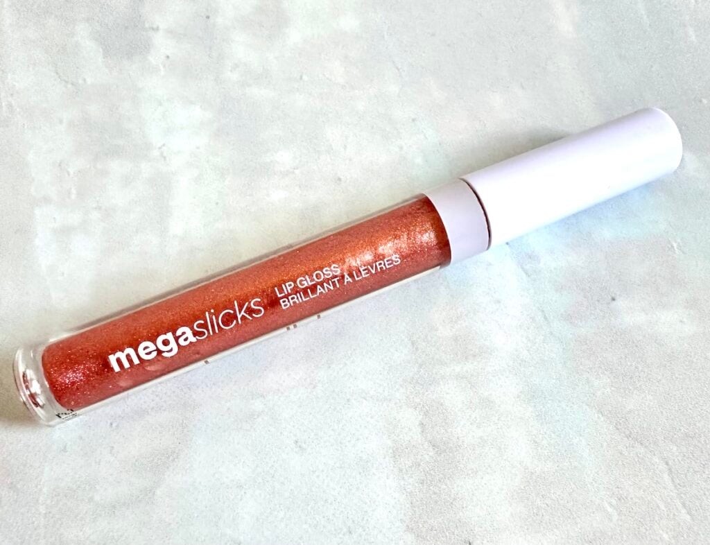 Wet N Wild MegaSlicks Lip Gloss in the shade Call Me Boss, flatlay.