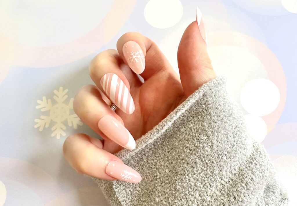 White Christmas Nails shown on right hand with blue sweater sleeve.