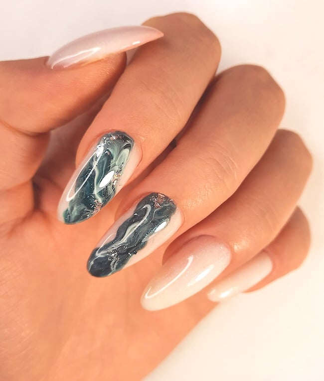 Greyish green and white marble swirl nails.