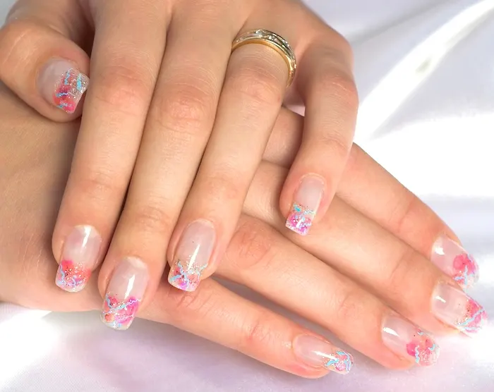 Multi-color glitter French tip nails.