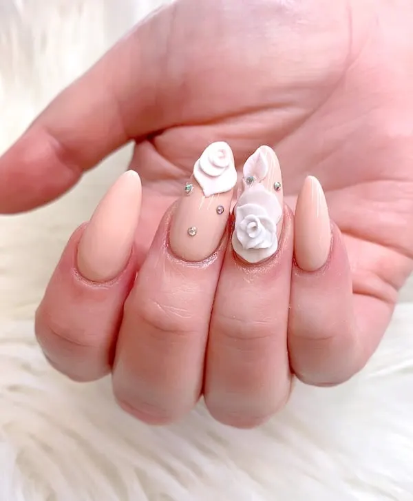 Nude rose almond nails in a 3d shape.