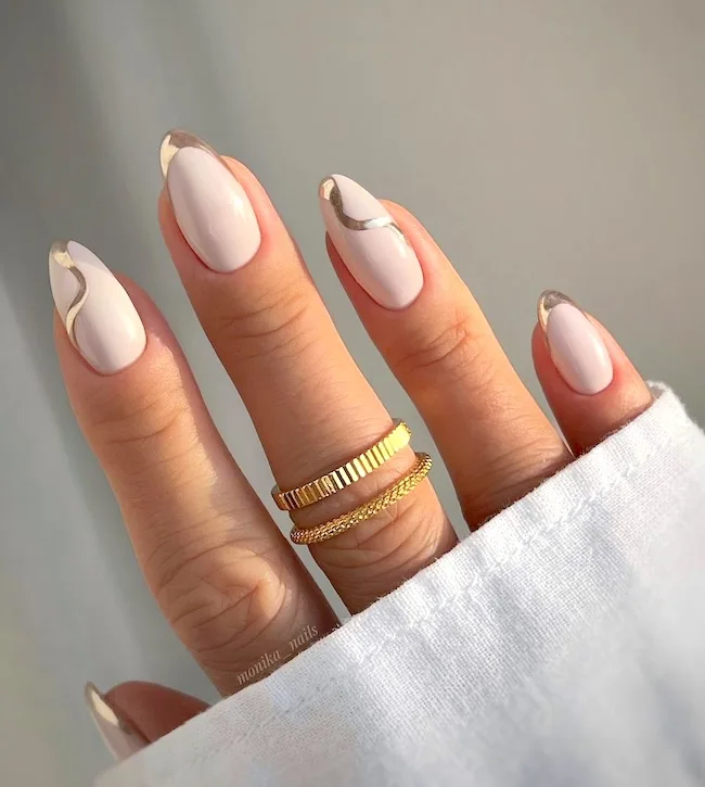 Gold and white swirl almond nails.