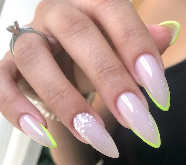 Sharp neon stiletto French tip nails.