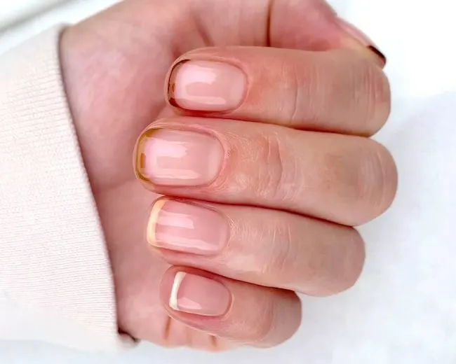 Short nude French tip nails.