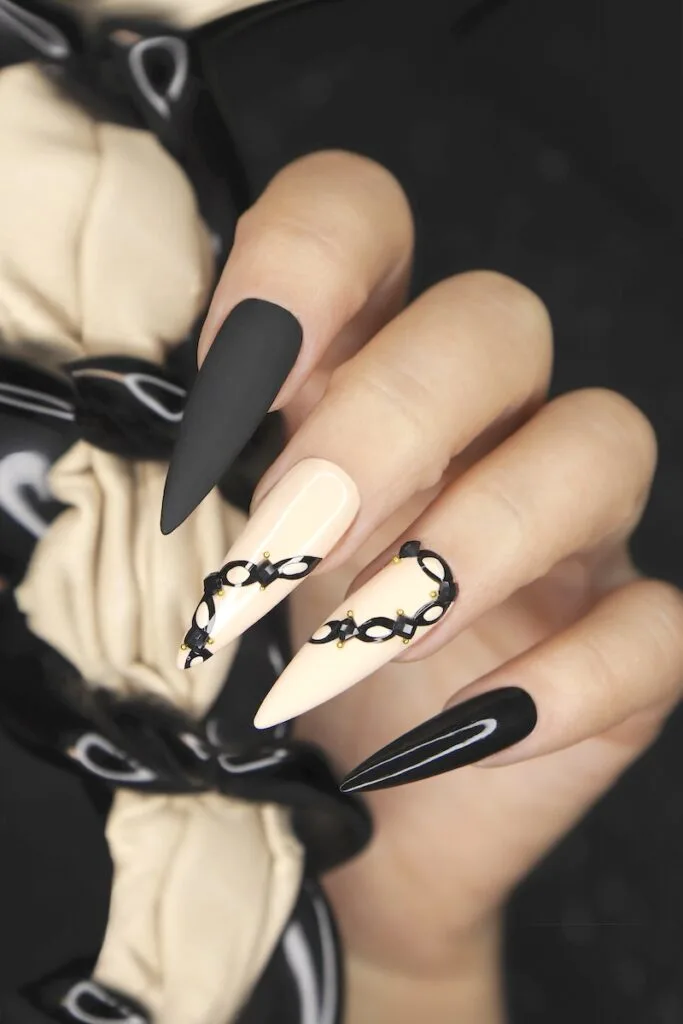 Beige black stiletto manicure on long nails.