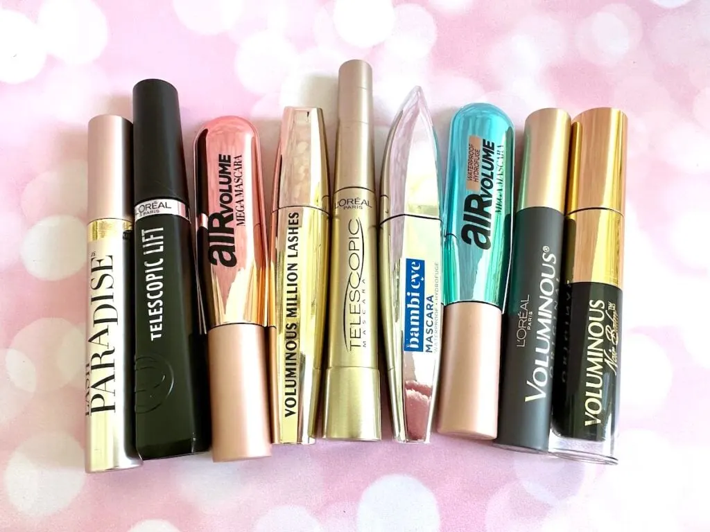 Flatlay of the best L'Oreal mascaras on pink twinkly background.