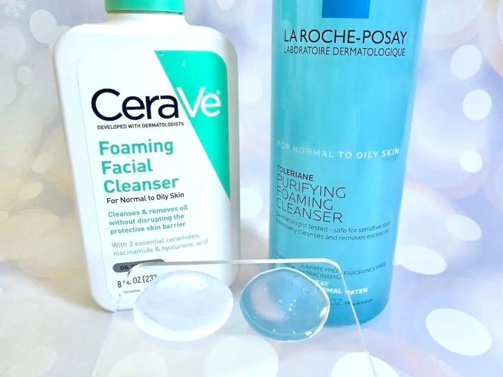 CeraVe Foaming Facial Cleanser vs La Roche-Posay Toleriane Purifying Foaming Facial Cleanser, bottles next to samples on clear cosmetic spatula.