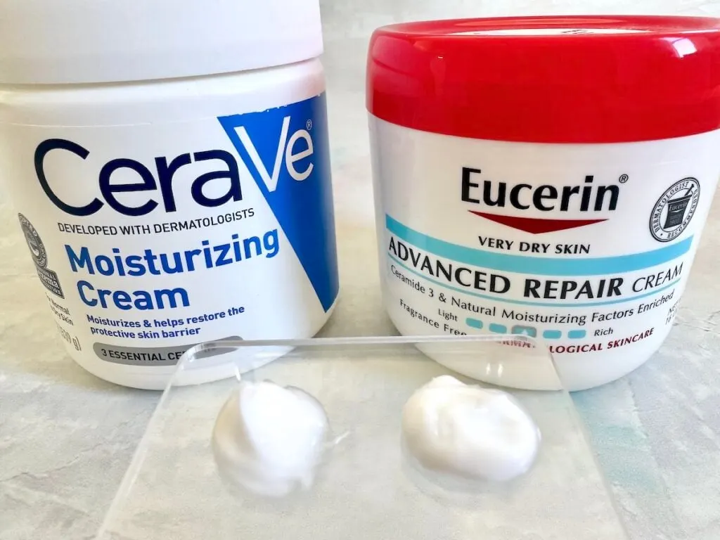 Cerave Moisturizing Cream and Eucerin Advanced Repair Cream jars, sampled on spatula.