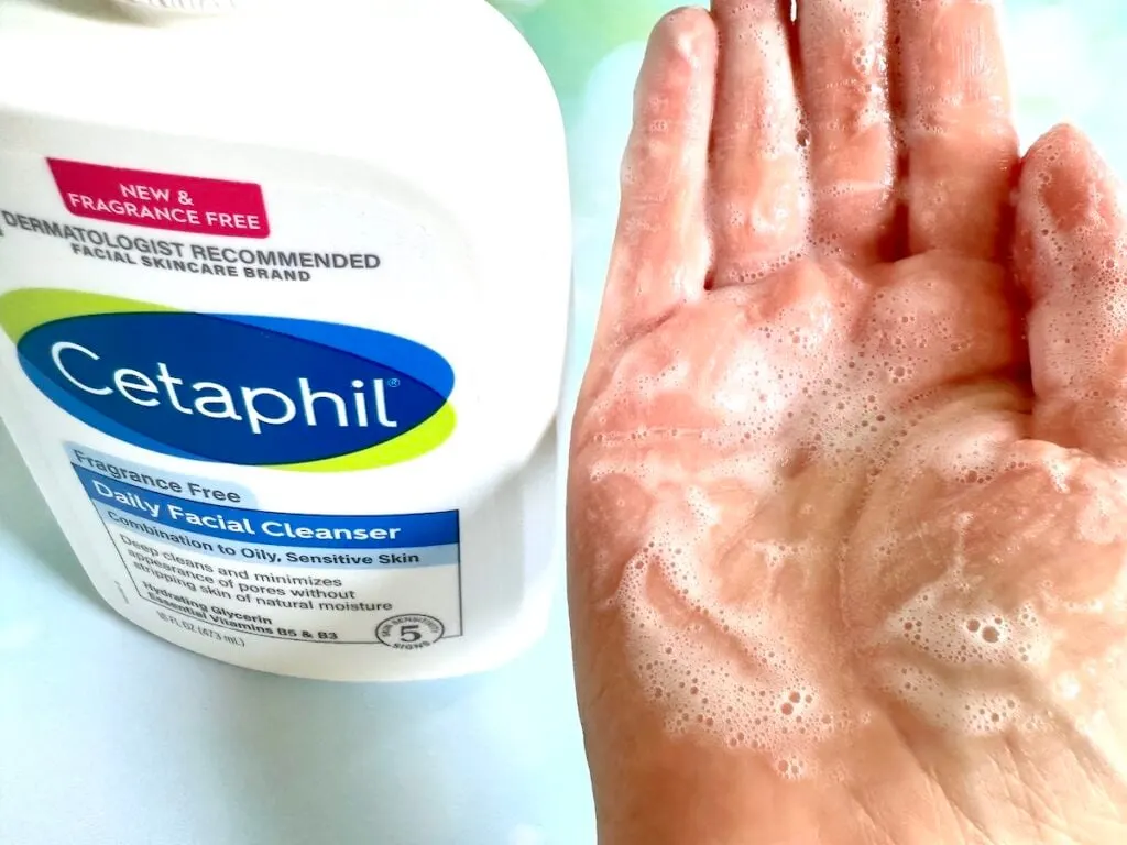 Cetaphil Daily Facial Cleanser bottle next to sample of gel turned to foam with water added in palm of hand.