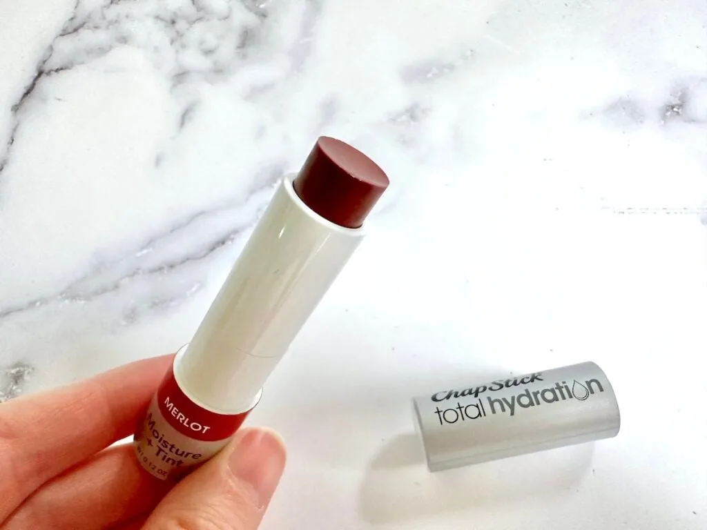 ChapStick Total Hydration Moisture + Tint Merlot Tinted Lip Balm, open with cap, handheld.