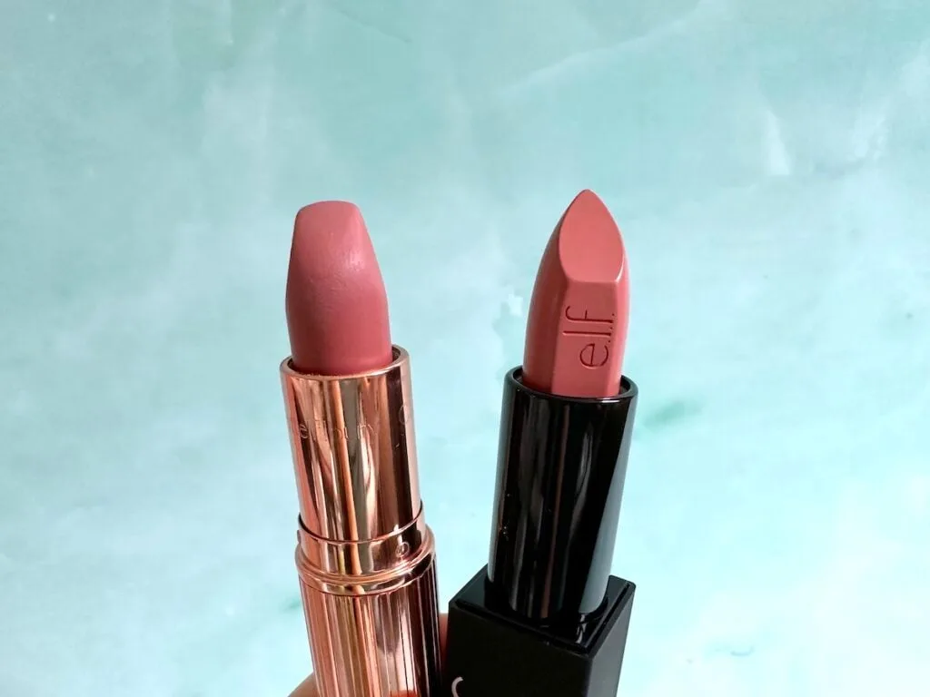 Charlotte Tilbury Pillow Talk lipstick and e.l.f O Face Satin Lipstick in Dirty Talk, handheld.