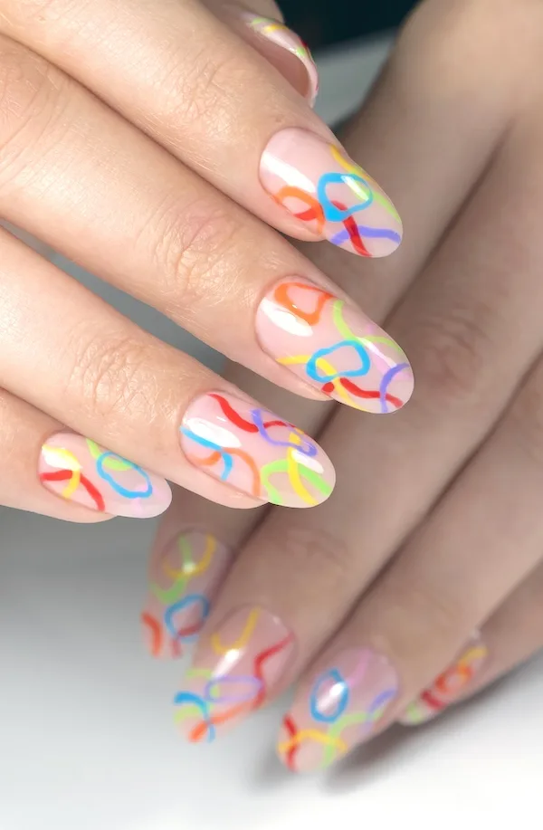 Mulit-colored rainbow rings on pink nail base.