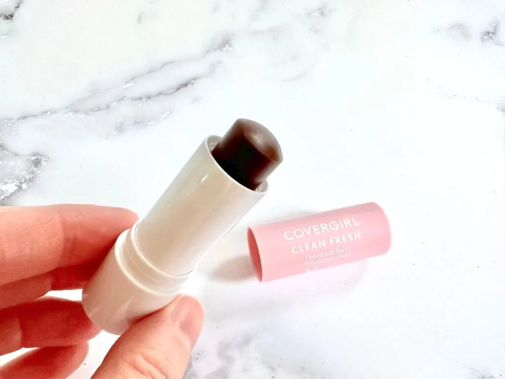 CoverGirl Clean Fresh Tinted Lip Balm in the shade Bliss You Berry, open with cap, handheld.