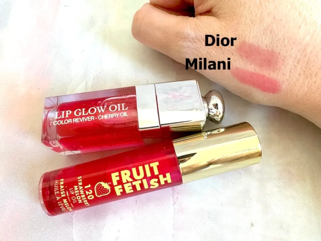 Dior Lip Glow Oil in the shade Cherry, and Milani Fruit Fetish Lip Oil in the shade Strawberry Melon, sampled on hand.