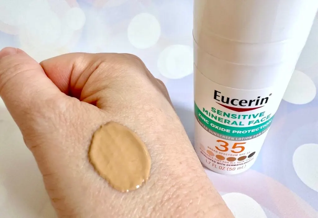 Eucerin Sensitive Tinted Mineral Face Sunscreen SPF 35 bottle next to sample on hand.