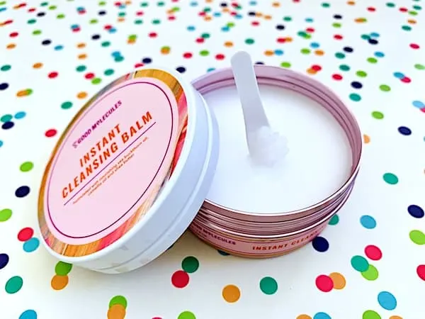 Good Molecules Instant Cleansing Balm open with spatula on colorful dot background