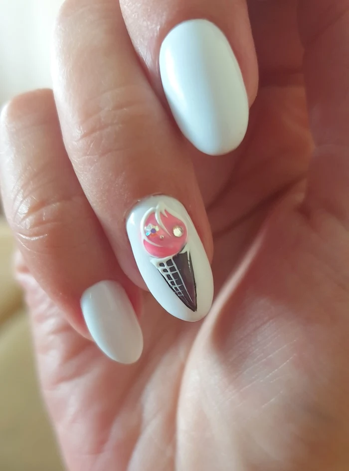 Whiet nails with pink cream cone on ring finger.