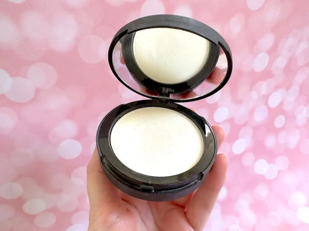 It Cosmetics Bye Bye Pores Poreless Finish Airbrushed Pressed Powder in the shade Translucent, handheld.