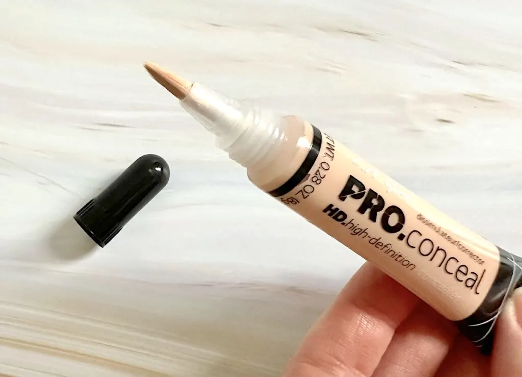 L.A. Girl HD Pro Conceal Concealer in the shade Buff, cap removed with brush applicator, handheld.