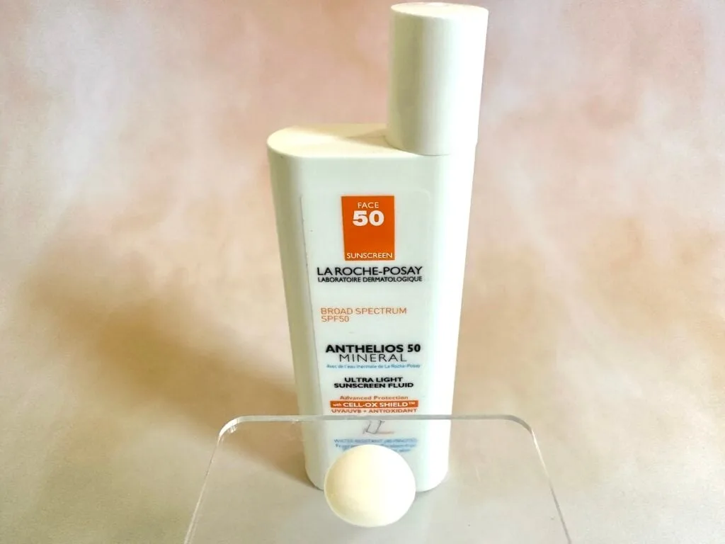 La Roche-Posay Anthelios Mineral Zinc Oxide Sunscreen SPF 50, bottle behind sunscreen sample on clear plastic spatula.