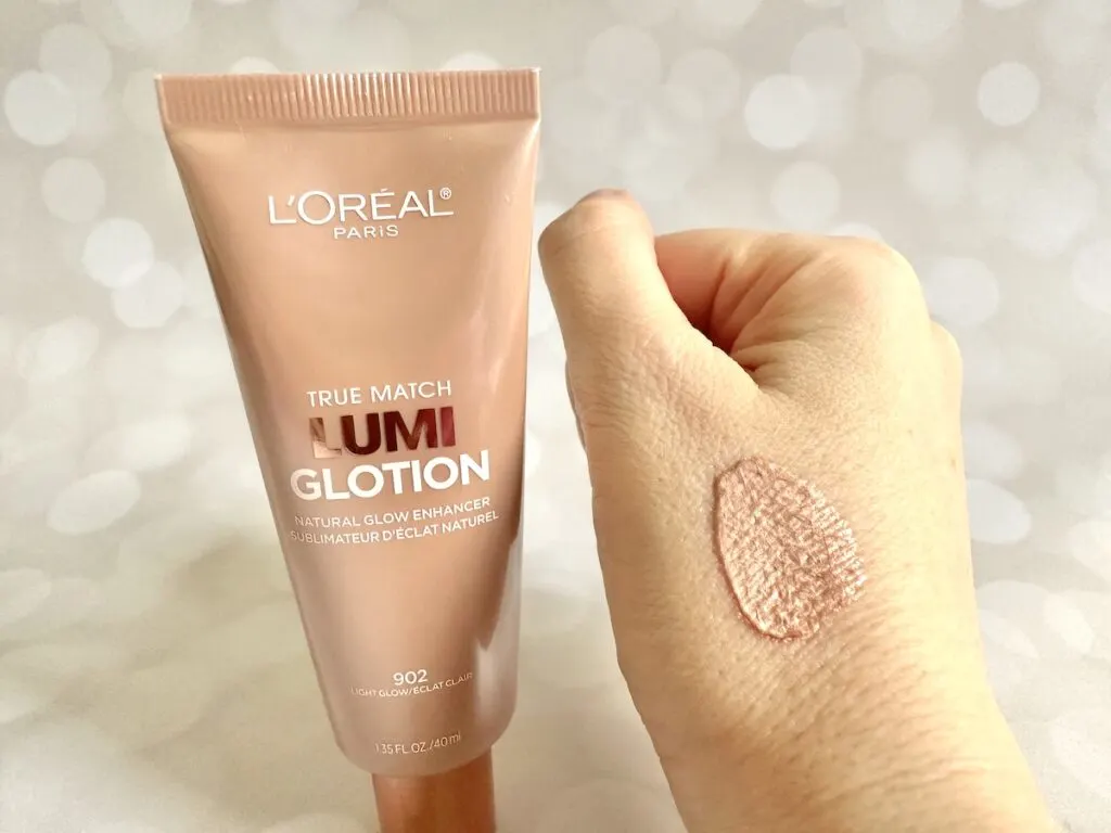 L'Oréal True Match Lumi Glotion Natural Glow Enhancer in the shade Light, tube next to sample on hand.