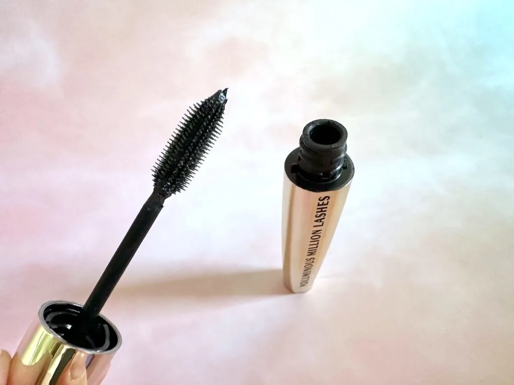 L’oreal Voluminous Million Lashes Mascara in the shade Blackest Black, open tube with handheld mascara wand.