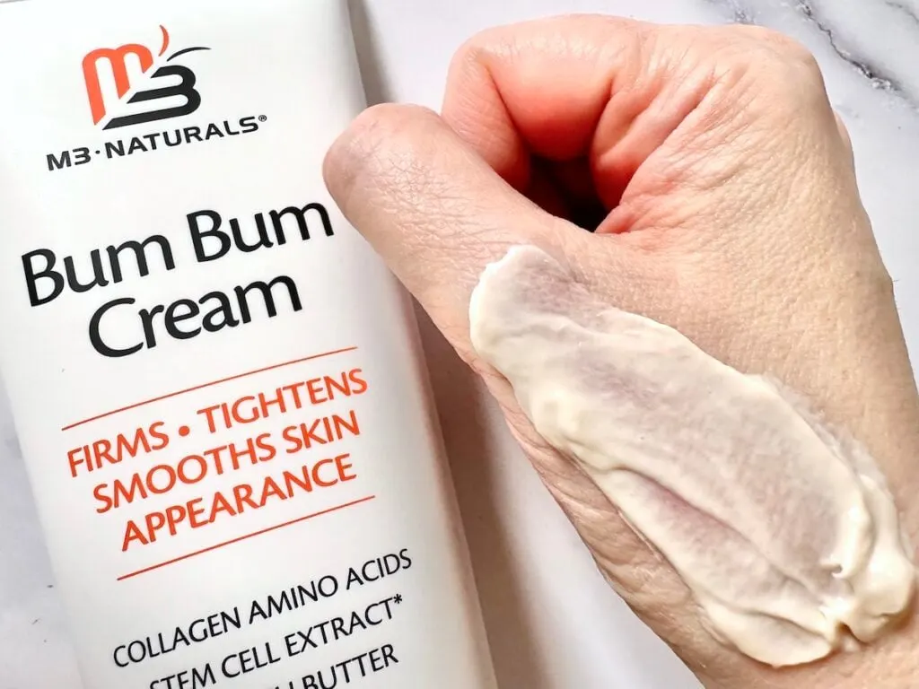 M3 Naturals Bum Bum Cream, flatlay, next to sample on hand.