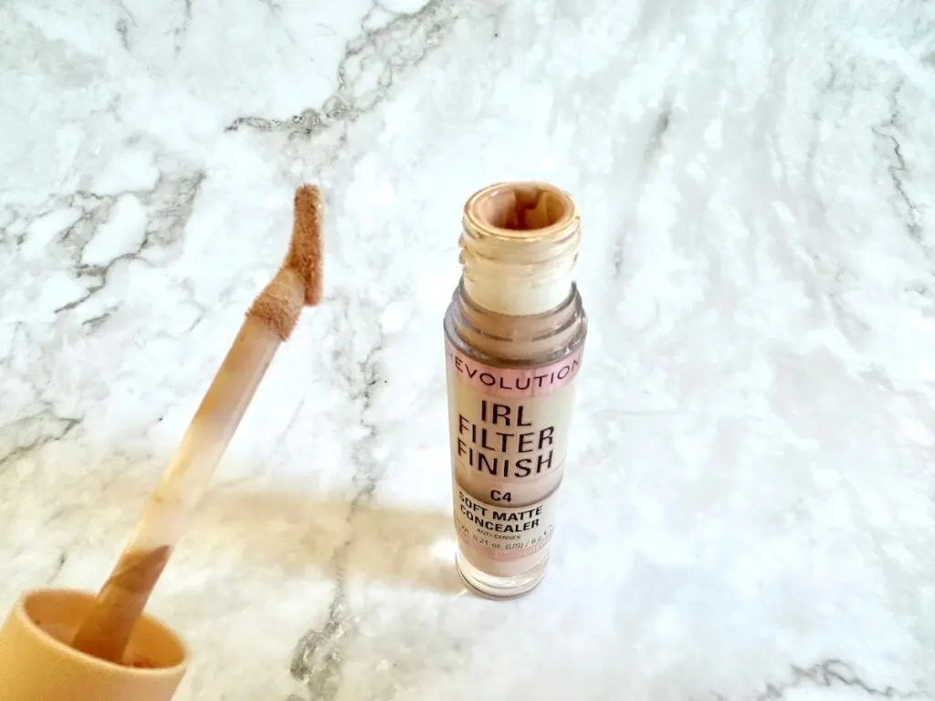 Makeup Revolution IRL Filter Finish Concealer in the shade C4, open tube with slanted applicator wand.