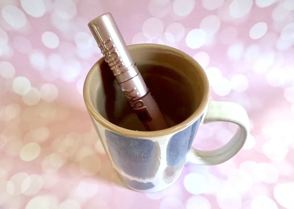 Maybelline Lash Sensational Sky High Mascara tube soaking in a mug of hot water.