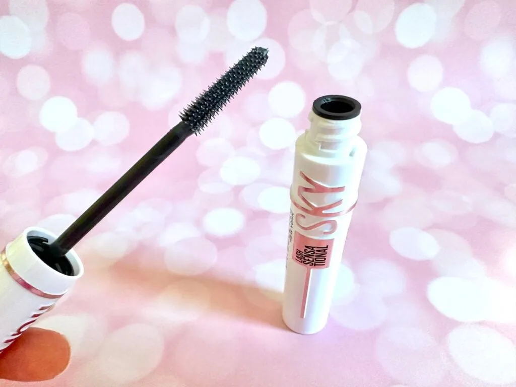 Maybelline Lash Sensational Sky High Serum Infused Lash Primer in Soft Black, open tube with mascara wand, handheld.